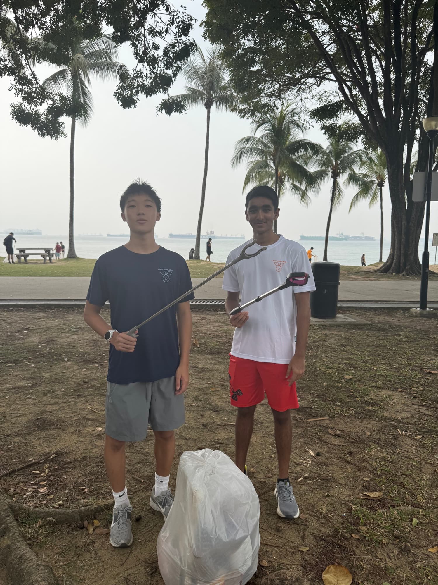 Sam and a friend with litter grabbers at East Coast Park